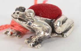 A 20th century white metal silver frog pin cushion