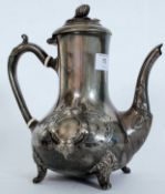 A 19th century Brittania metal teapot raised on decorative feet with ovoid body raised on relief
