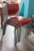 A set of 4 metal industrial stacking chairs, each with painted metal supports and  velour panel