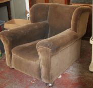 A large 1930`s Art Deco vintage wingback armchair of deep proportions having shaped arms and thick