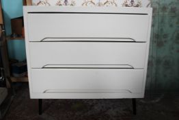 A 1950`s painted wooden retro chest of drawers raised on ebonised tapered legs with a series of