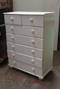 A 20th century Shabby Chic painted pine chest of drawers raised on bun feet with short drawers over