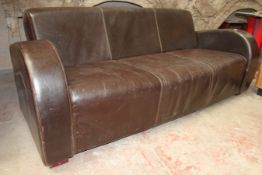 A contemporary Art Deco brown leather sofa settee / couch. Shaped arms and back rest upholstered in