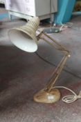 A vintage mid 20th century Industrial anglepoise lamp by Ledu being raised on a lozenge shaped base