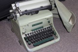 A vintage enamel painted Imperial typewriter in green complete with the original vinyl cover. Model