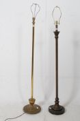 Two early 20th century standard lamps in brass, both with terraced bases and tall stems with