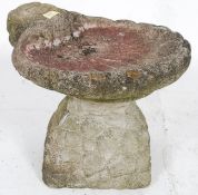 A 20th century raised garden stone bird bath in form of a shell ste on a plinth base of conical
