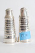 A pair of silver plate condiment shakers in the form of Light houses with markings to base. weight