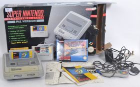 An original Super Nintendo gaming console with original box, controllers etc and a small quantity of