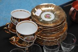 A collection of gold lustre china cups and saucers with chintz centres