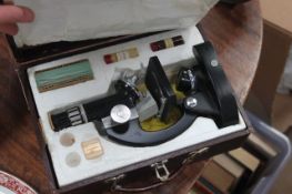 A vintage 20th century cased microscope complete with accessories