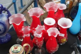 A good collection of end of day glass vases etc with embellished fronts, all in red.
