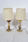 A pair of decorative brass and ceramic oil lamps in the neo - classical style both having fabric