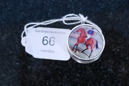 A silver white metal (stamped 925) and enamel set round pill box depicting horse and rider