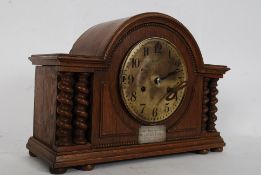 A 1920`s oak mantel clock with barley twist columns and plaque to front