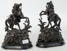 A pair of late 19th century spelter marley horses with handlers being raised on naturalistic plinth