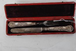 A 19th century William 4th childs knife and fork set having rococo silver handles with steel
