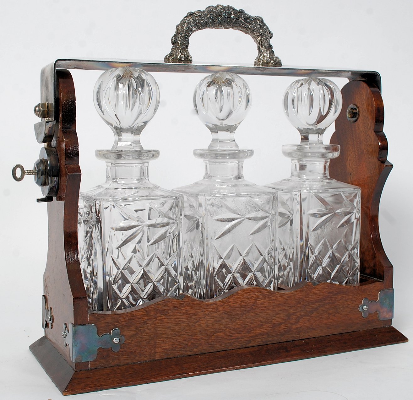 A 19th century Victorian oak and silver plated Tantalus with ornate ivy epns handle and mounting
