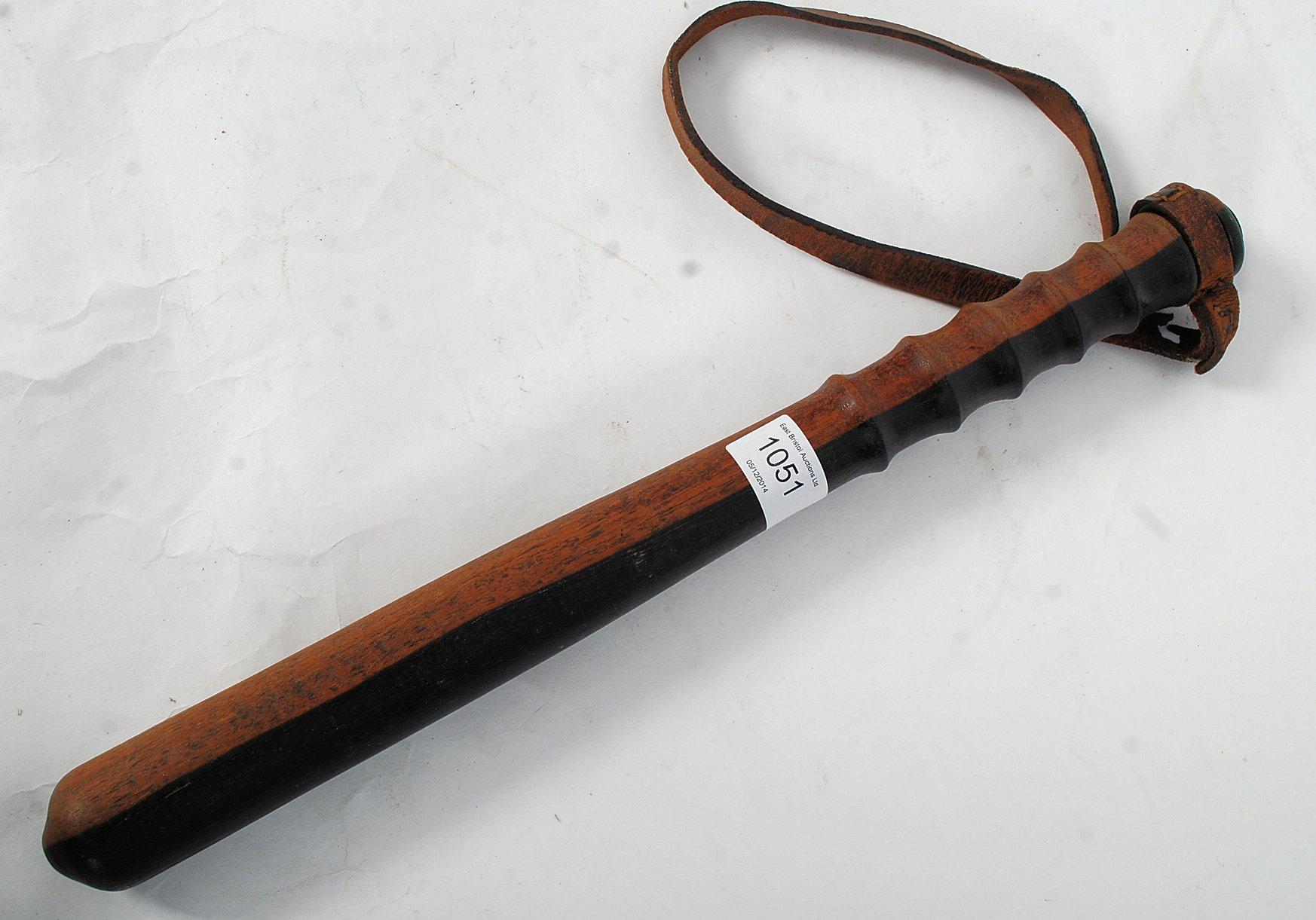 A 19th century two tone mahogany policeman's truncheon / tipstaff of tapered form with shaped handle