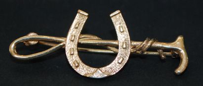 9ct gold riding crop and horseshoe brooch. Weight 2.6g.