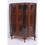 A 1930's Art Deco walnut demi lune china display cabinet being raised on stub cabriole legs with