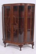 A 1930's Art Deco walnut demi lune china display cabinet being raised on stub cabriole legs with