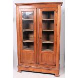A 19th century French walnut / fruitwood armoire bookcase raised on shaped base with glazed doors