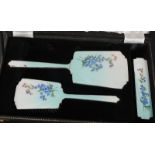 An early 20th century ladies cased dressing table set of decorative form having enamel worked back