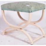 A 1950's Shabby Chic X-framed dressing table stool being painted with green velour seat atop