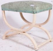 A 1950's Shabby Chic X-framed dressing table stool being painted with green velour seat atop