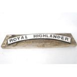 A reproduction cast metal Royal Highlander railway sign (AF) being affixed to a railway sleeper.