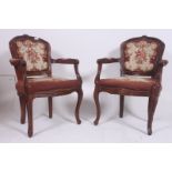 A pair of 20th century French fauteils armchairs with shaped legs have embroidered  tapestry foliate