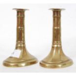 A pair of Georgian pusher brass candlestick holders, fluted design with ribbing to central shaft