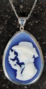 A silver cameo pendant necklace on a whi