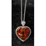 A white metal and amber style heart shap