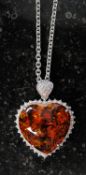 A white metal and amber style heart shap