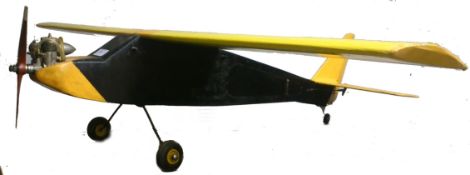 A vintage 20th century radio controlled model aeroplane in yellow and black colouring, fitted with