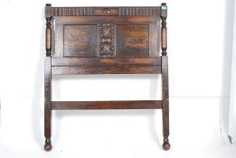 A 1920`s Jacobean revival oak single bed together with 2 others.