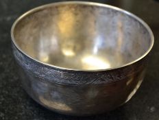 A Chinese silver bowl having character marks to the base with a chase decorated rim. 4.75oz