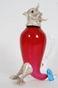 A silver plated cranberry glass claret jug in the form of a parrot