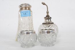 A collection of white metal and hallmarked silver topped glass canisters / shakers etc. 4 in total