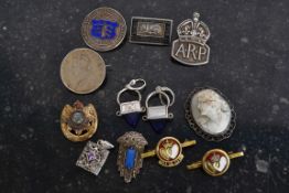 A collection of hallmarked silver badges and brooches to include WWII ARP badge, coins made into