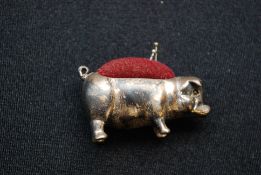 An early 20th century hallmarked sterling silver pin cushion in the form of a pig bearing