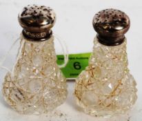 A pair of hallmarked sterling silver topped condiment shakers.