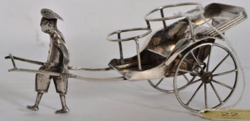 A white metal detailed model of a rikshaw pulling oriental man. 14cm long.