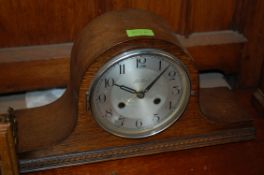 A vintage 1930`s oak dome top mantel clock retailed by Kemp Bros, Bristol. The case finished with