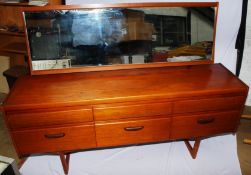 A 1970`s teak mirror back dressing table in the manner of Mogens Kolo raised on tapered legs with