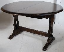 A good quality Ercol beech and elm refectory draw leaf extending dining table. Raised on lyre