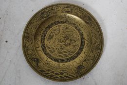 An unusual Chinese brass plate being chase decorated to the front with scenes of dragons.