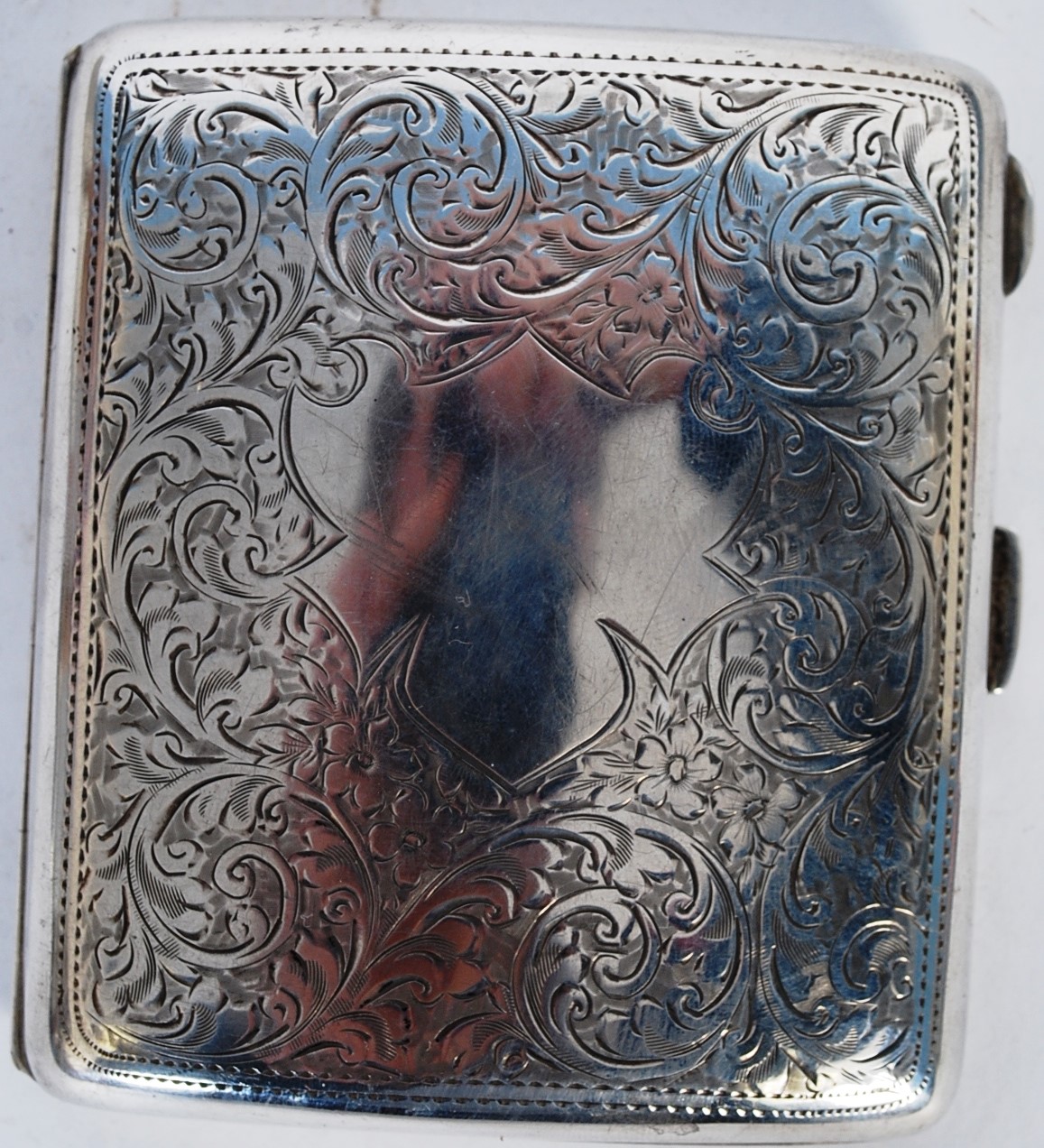 A silver chased 1921 hallmarked wind shield cigarette case hallmarked Birmingham .Weight 91gms.